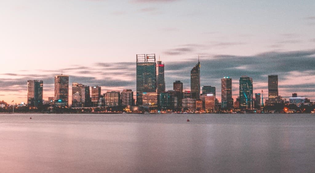 Perth city skyline and Swan River viewed across the water at dusk.